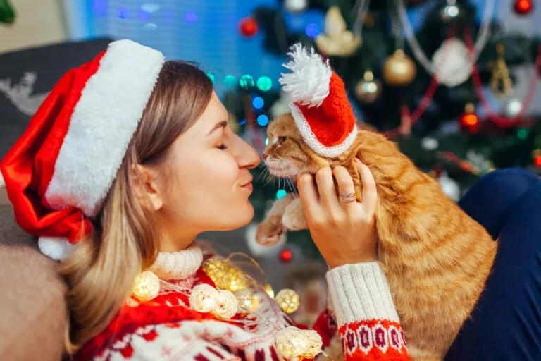 Žena i mačka s božićnim kapicama